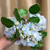 Bundle of three blue real touch hydrangea blooms with a realistic green leaf stem arranged in a decorative vase, featuring lifelike petals and classic Southern-inspired home décor styling.