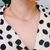 Woman wearing a marquise cut sparkle tennis necklace with an elegant dress