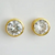 Close-up of sparkling bezel-set crystal stud earrings with a gold finish