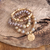 Rose blush beaded bracelet stack featuring faceted glass beads, semi-precious stones, and a hammered gold-tone coin charm.