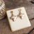 Hammered gold cross earrings with a luminous pearl-inspired center stone