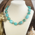 Turquoise chunky statement necklace with asymmetrical beads and gold-tone spacer accents.