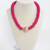 Hot pink wooden bead necklace featuring a bold gold center bead and adjustable chain