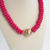 Hot pink wood bead statement necklace with a textured gold center bead