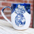 Exclusive Blue & White Pineapple Mug by Alabama Vitrified, handcrafted by Alabama artist Cari Cleckler. White pottery mug featuring a raised pineapple design finished in a classic blue-and-white motif, symbolizing hospitality, welcome, and Southern style. Available exclusively from Pine Apple Mercantile Company.