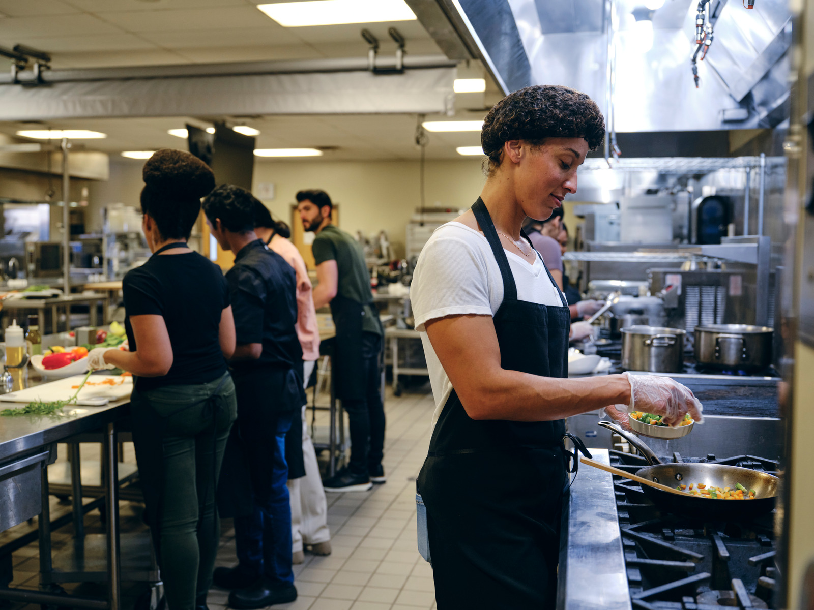 A restaurant kitchen full of employees working