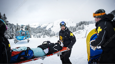 Search and Rescue team members racing towards a yellow helicopter on a helipad