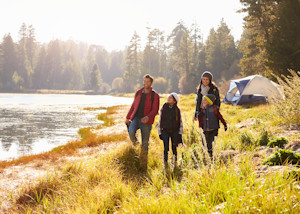 Family hiking near riverside campsite