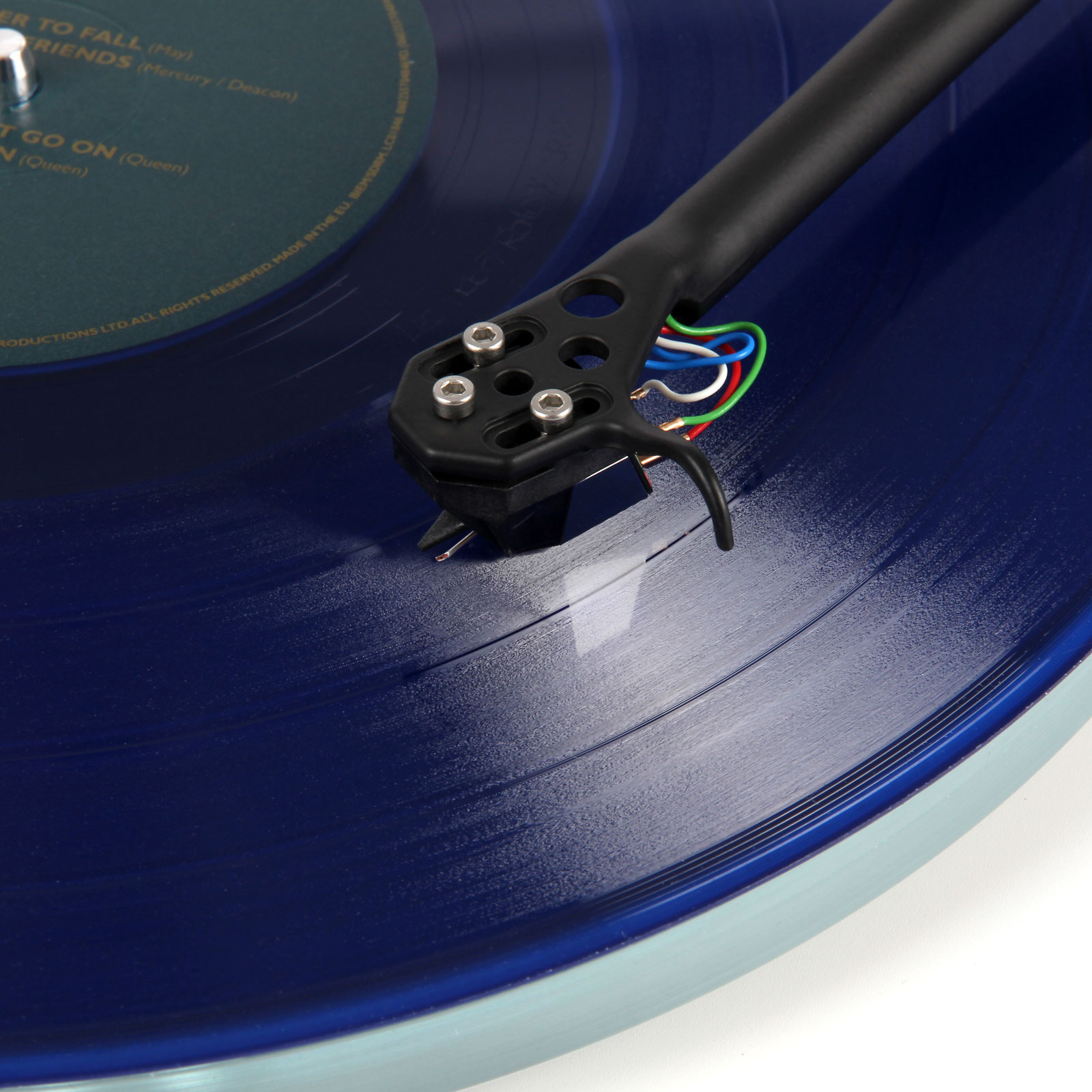 Top view close up view of a cartridge playing on a blue record