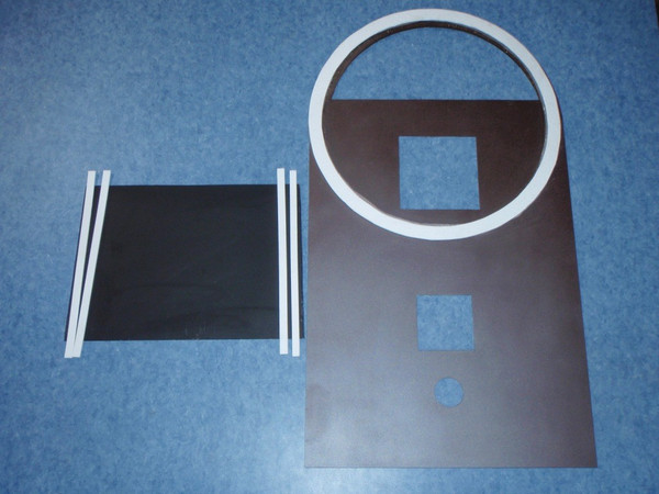 Here is a top plate painted bark brown metallic and a divider plate painted black. The round white gasket fits underneath a 55 gallon steel drum; it prevents the exhaust gases from escaping into the room. Gaskets on both sides of the divider plate also divide the exhaust gases from the incoming air for combustion around the burn tunnel.