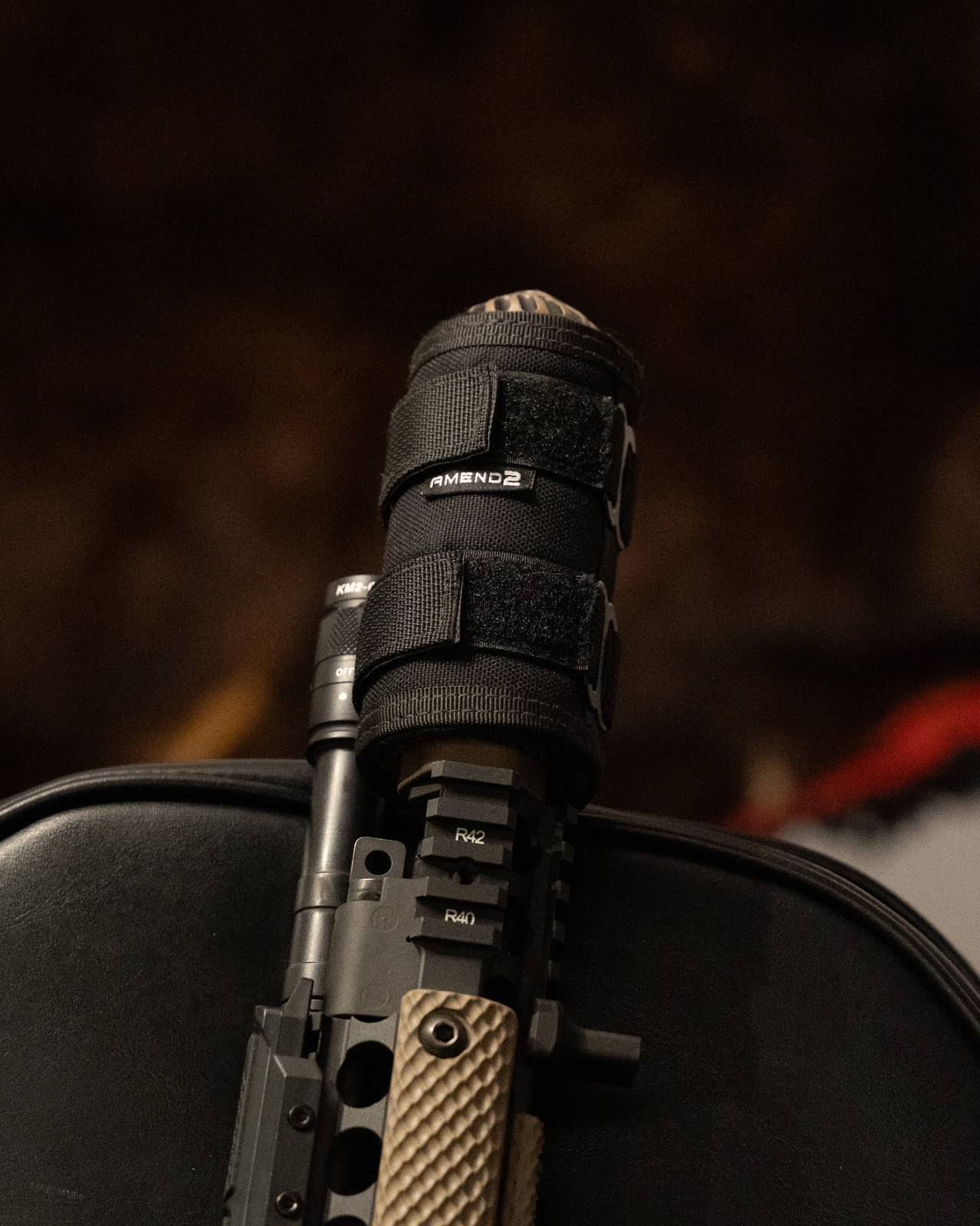 Amend2 Mirage Cover mounted on a suppressed AR rifle with a black cover and Coyote furniture