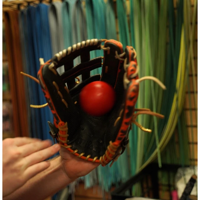 A weighted ball sitting in the pocket of a glove