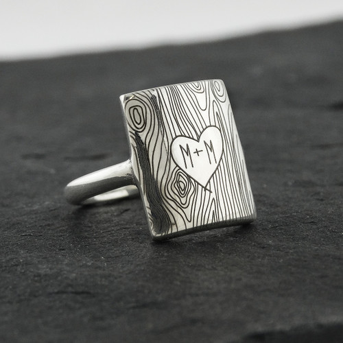 Custom engraved initials on a tree trunk ring