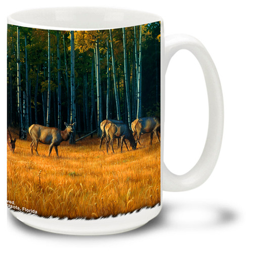 Beautiful Elk on a grassy field with trees.