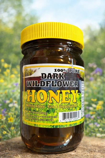 Dark wildflower honey showcasing its rich amber-brown color and natural golden highlights, with a deep, inviting appearance that reflects the beauty of pure wildflower honey.