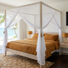 White four poster super king bed with a polyester box mosquito net as a bed canopy