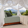 Bed canopy of cotton mosquito netting tied open