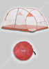 Freestanding travel mosquito net set up, shown with its round red carry bag