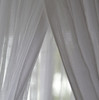 Cotton mosquito net curtains parted at the centre opening