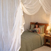 Cotton box mosquito net over a single bed in a cosy bedroom