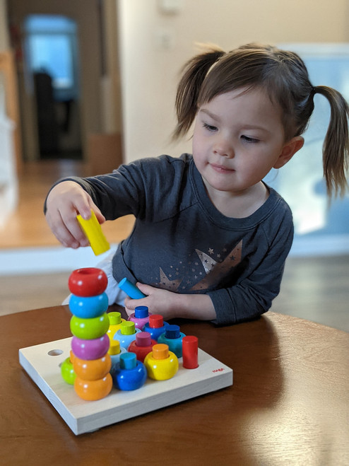 Child playing with Rainbow Whirls Pegging Game