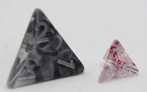 Mystery Loot: Halfling Dice close up of big grey triangle die and little clear and pink triangle die