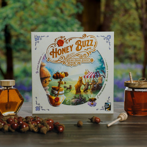 Honey Buzz game box sits beside a jar of honey and a pile of acorns