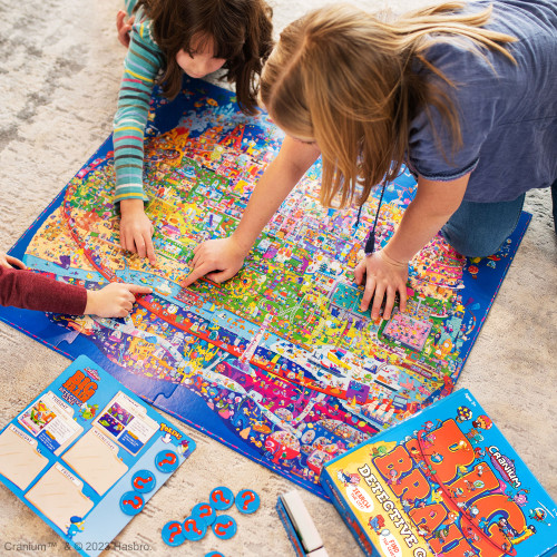 Three children working on a mystery with the oversized gameboard on the floor