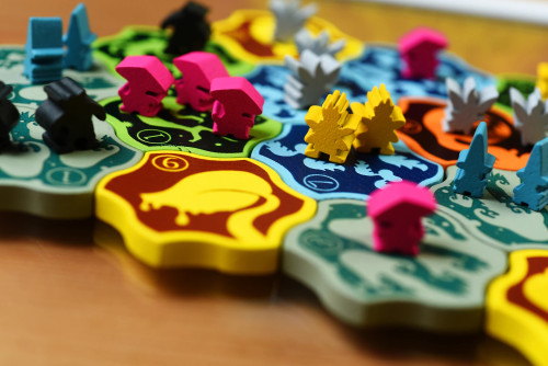 Power Plants gameplay, featuring sturdy colorful tiles and wooden player tokens in the shapes of fairies, gnomes and mushrooms