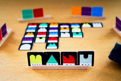 game set up, with correlations to scrabble set up with tiles and a tile holder