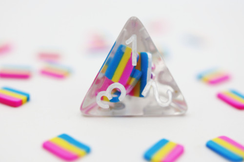 Close up of one clear dice with mini pansexual flags