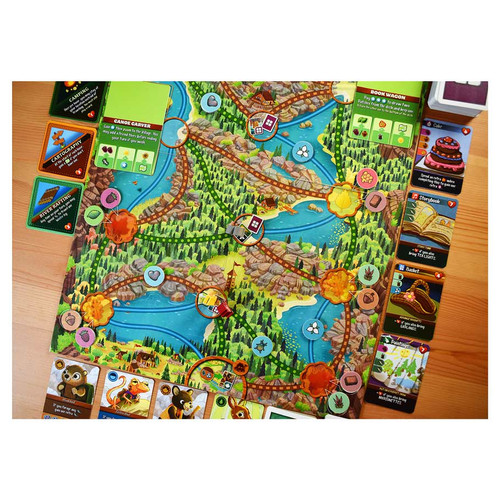 Game board lay out featuring a map with paths and different types of game cards 