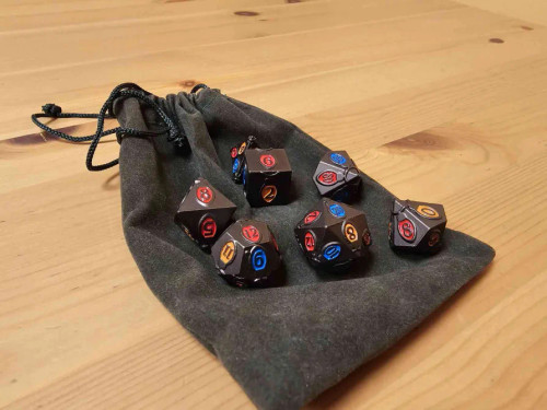 Black dice set, with red, blue and orange light bulbs with numbers, resting on a black cloth bag