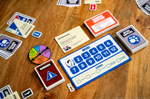 Game components including a spinner, weeks and Rewards and Office Supply cards