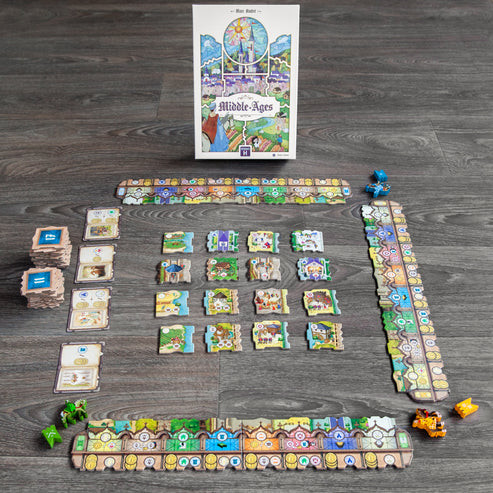 The game laid out in in tiles into a square, in front of the game box featuring cards and player tokens