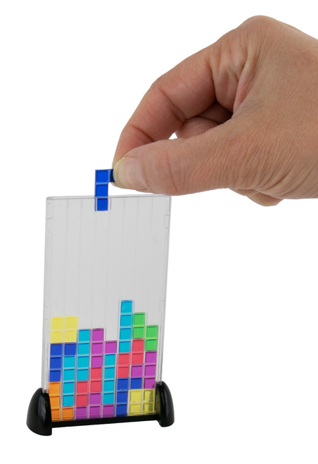 A hand drops a piece into World's Smallest Tetris