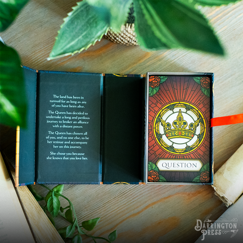 The game box, open to reveal the back of the card deck and an inscription  