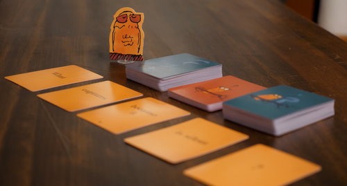 game set up with cards and a cardboard stand up owl