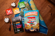 Game box with its components, tiles and dry erase markers and a roll up map/board