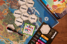 A color coded tile card, with hand written words on the map