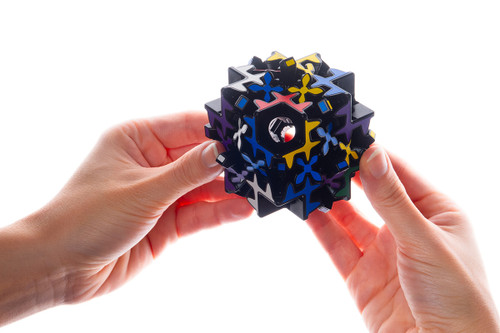 A pair of hands attempts to solve the puzzle