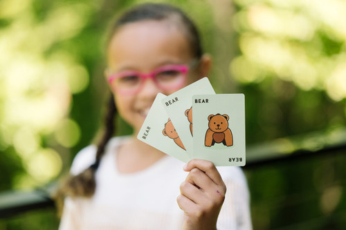 A child shows off three bear cards