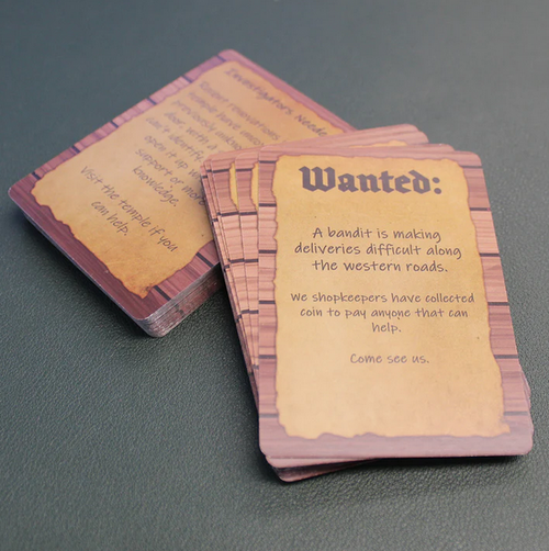 Example card with text beginning, "Wanted: A bandit is making deliveries difficult along the western roads..."