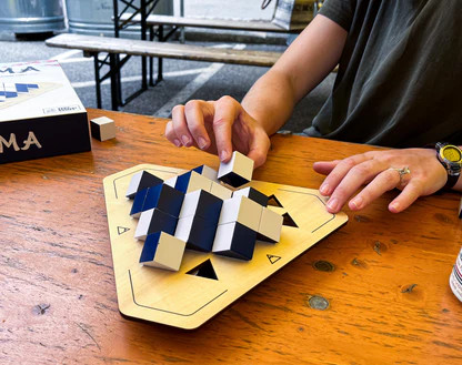 A pair of hands places a piece on the board