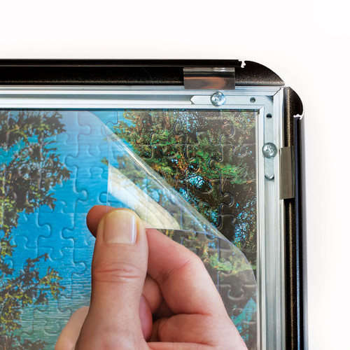 Protective clear film over the top of a framed puzzle