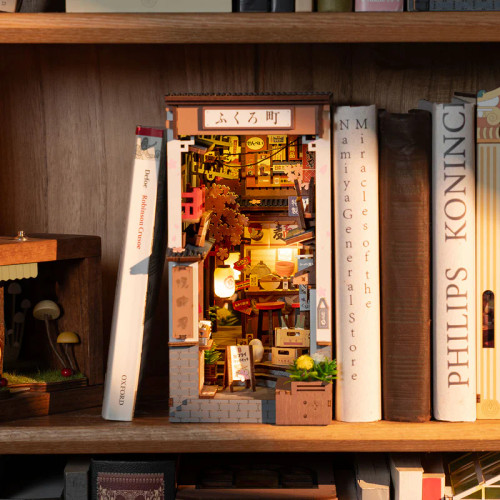 The completed model on a bookshelf, its light illuminated