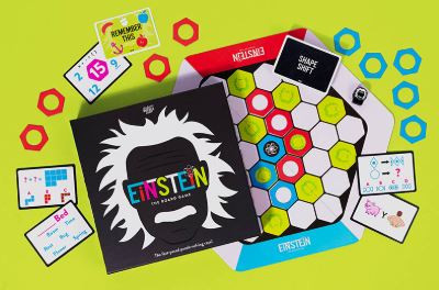 The game set up with green, white, red and blue colored shapes and puzzle cards
