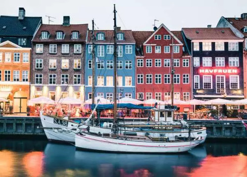 a boat in front of various colorful connected homes
