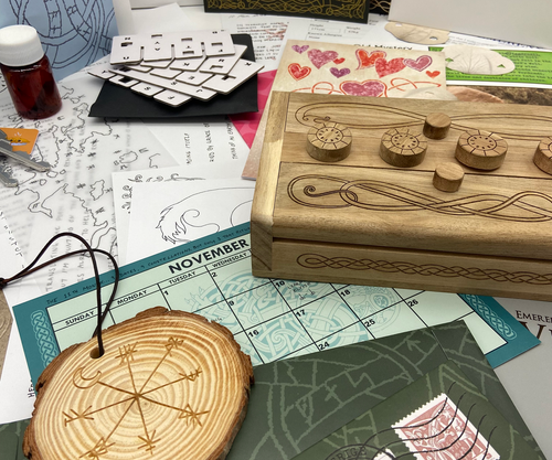 Puzzle components, including a woodcut pendant, puzzle box, calendar and more