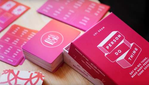a pink red card box with white font and card deck with words